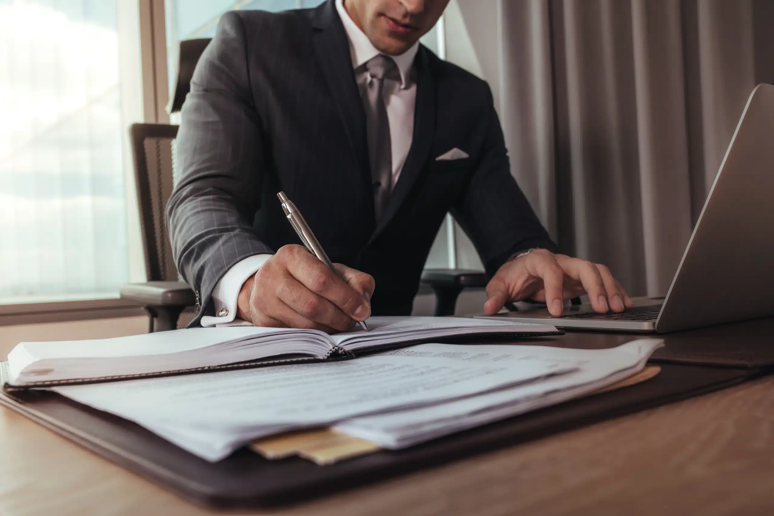 lawyer-writing-personal-injury-demand-letter lawyer sitting at desk writing personal injury demand letter