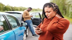 woman in pain after car accident calling personal injury lawyer about potential lawsuit post-accident