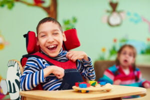 disabled special needs child smiling in a classroom