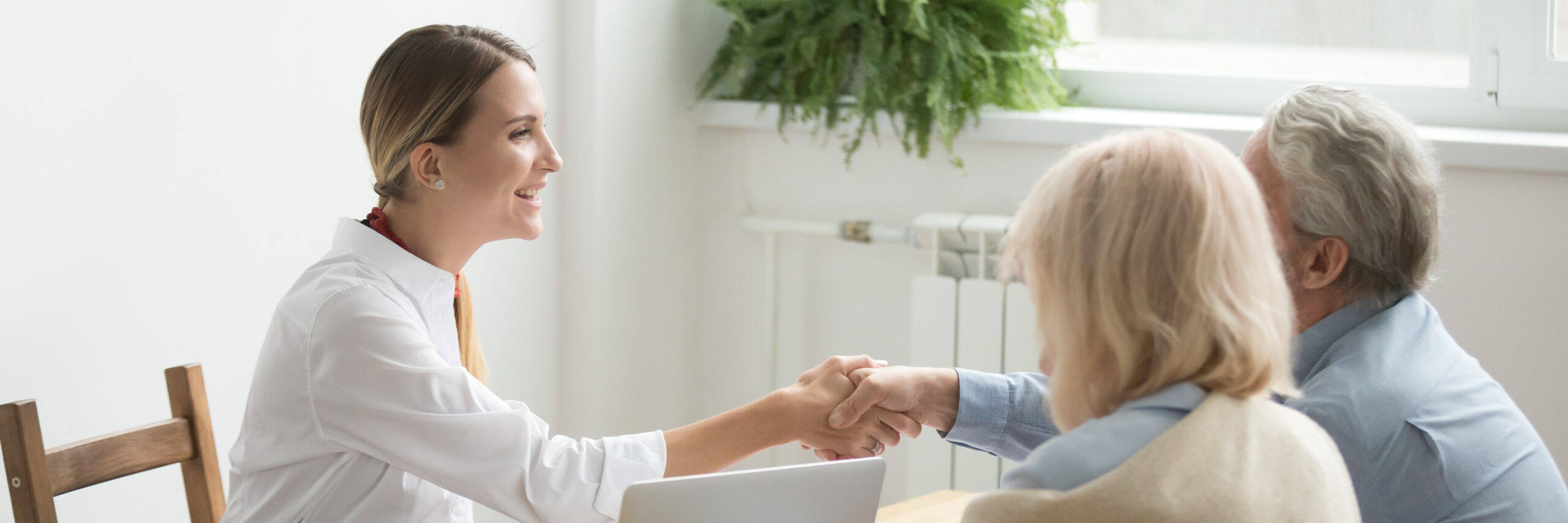 retired couple shaking hands with a social security benefits representative after car accident or surgical error