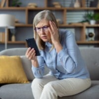 older woman looking at a phone possible scam