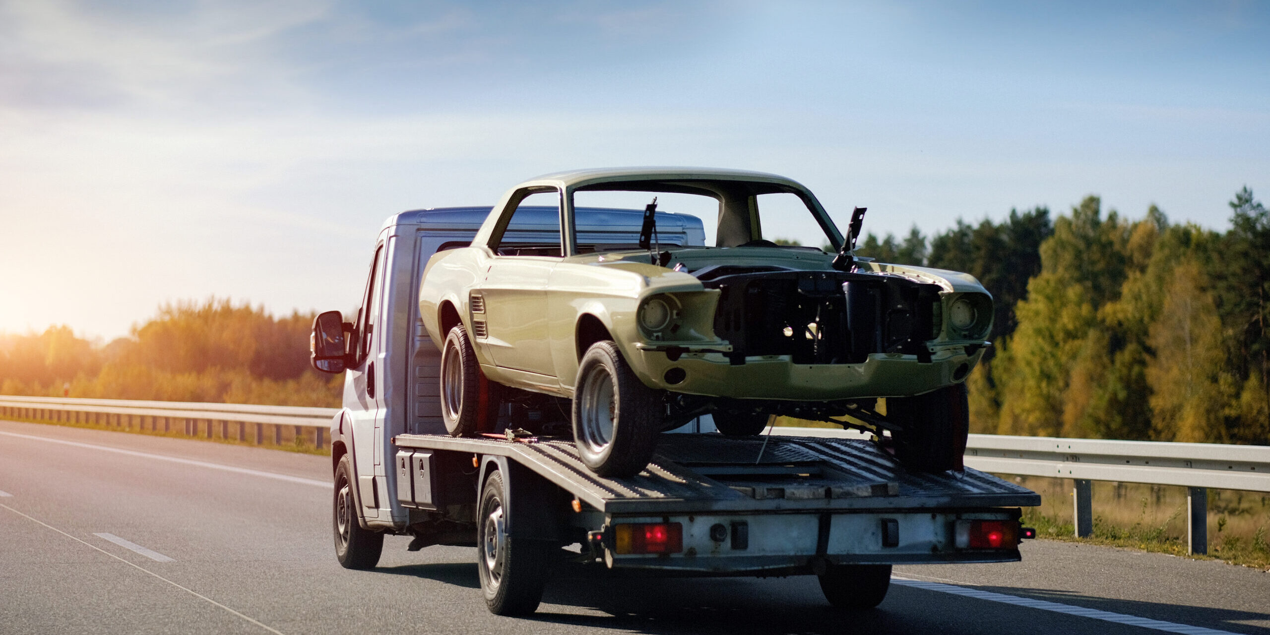 classic car broken down and being towed