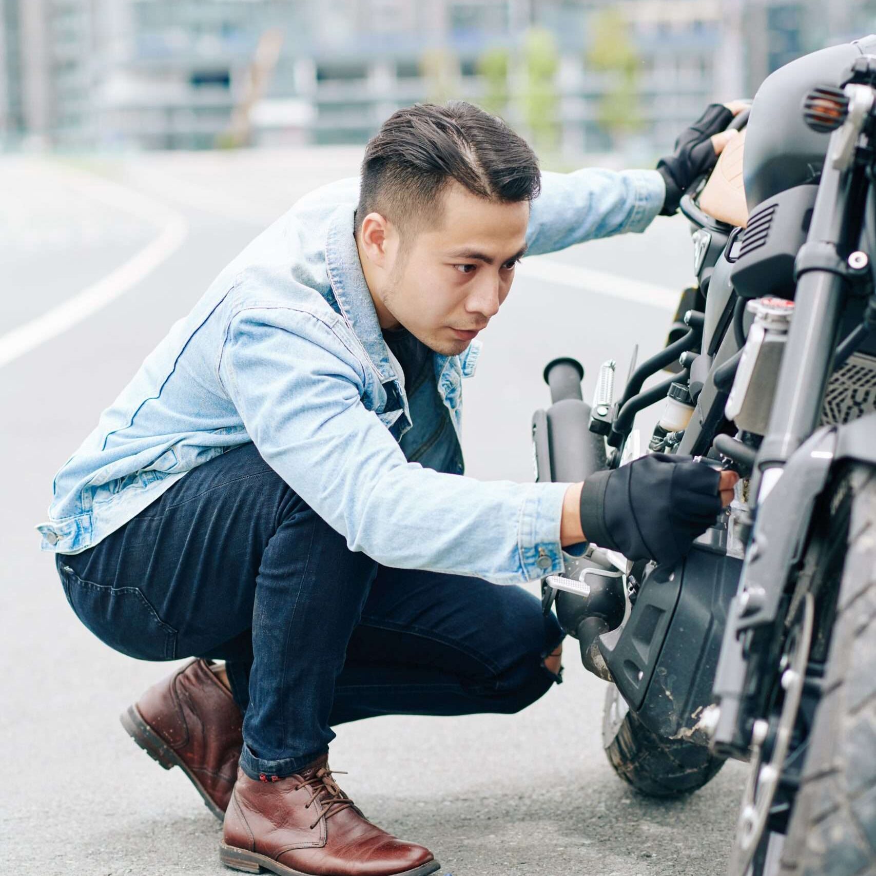 man fixing motorcycle