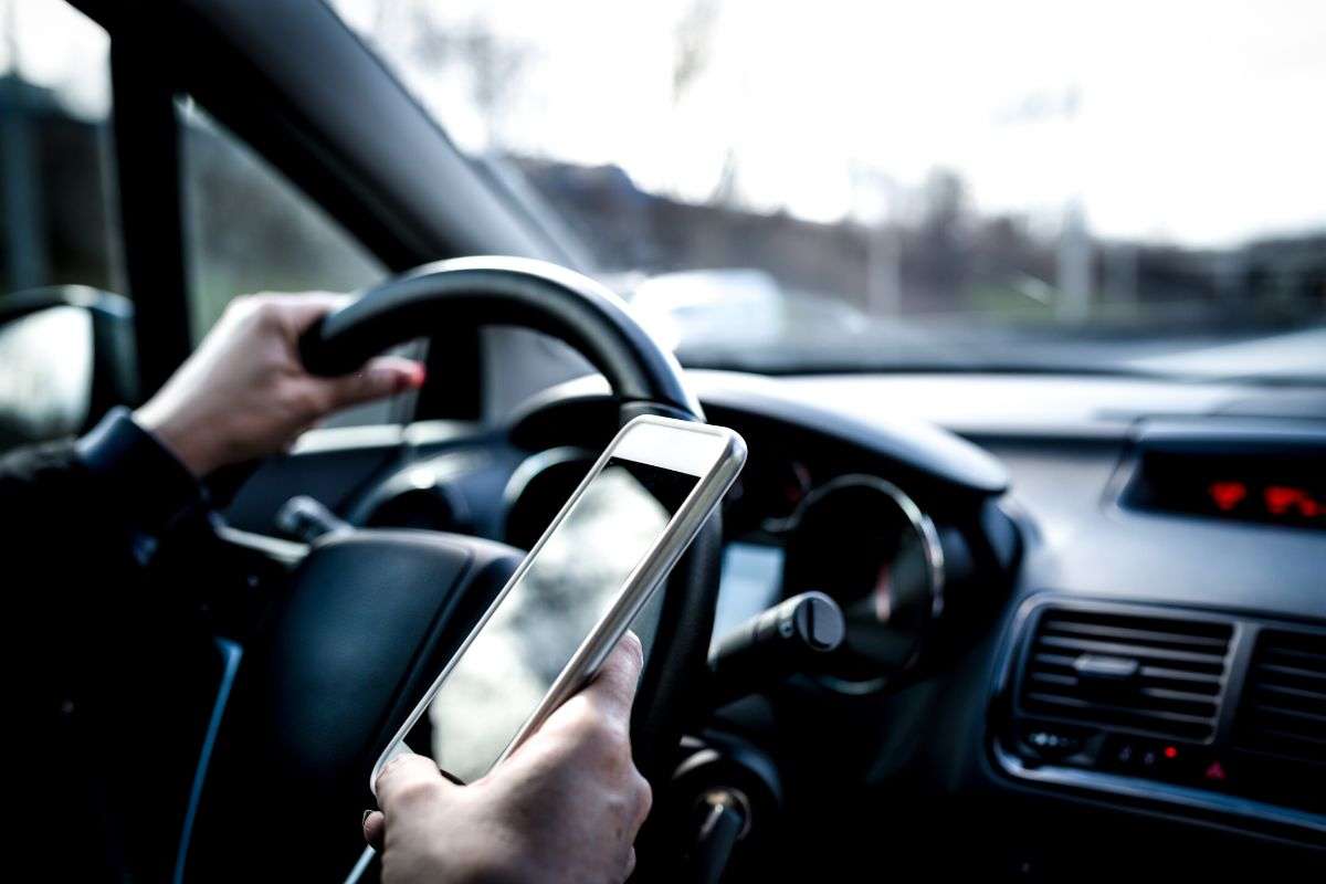 person texting and driving; potential distracted driving accident